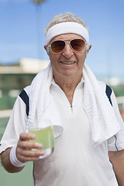 ältere mann, trinkt limonade im freien - tennis active seniors healthy lifestyle senior men stock-fotos und bilder