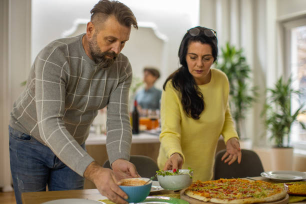 istock Modern Caucaisan couple setting the food and drinks for the dining table 1383008109