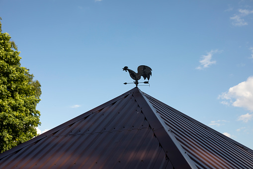 Rooster on the roof. The roof of the veranda. Weathervane to determine the direction of the wind.