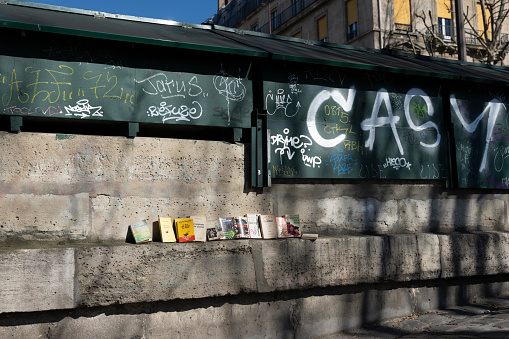 Graffiti and books for sale on the right bank of the Seine in Paris, France,
