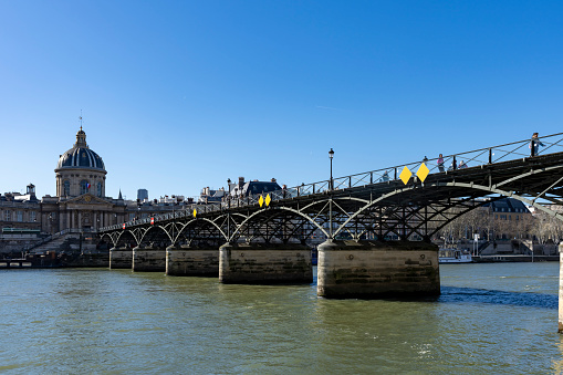 People walking over the Pont des Arts Paris, France.