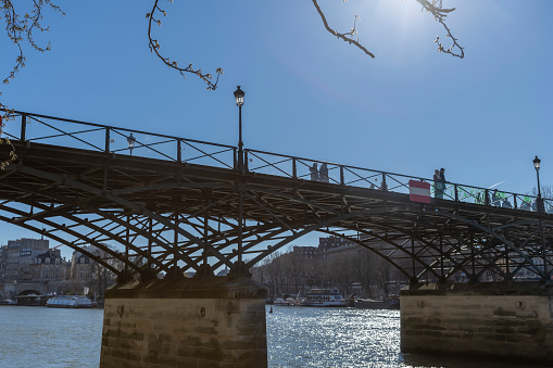 People walking over the Pont des Arts Paris, France.