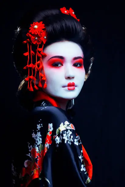 young pretty real geisha in kimono with sakura and decoration