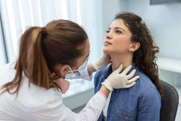 medicina, assistenza sanitaria e concetto di esame medico - medico o infermiere che controlla le tonsille del paziente in ospedale. endocrinologo che esamina la gola della giovane donna in clinica - thyroid gland foto e immagini stock