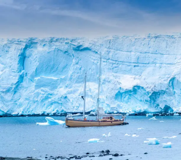 Photo of Sailing to the Antarctic Peninsula. Sail boat anchored on the glacier shores of Damoy Point, Near Port Lockroy. Antarctica