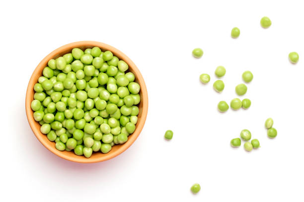Green peas in a ceramic plate on a white background Green peas in a ceramic plate on a white background green pea stock pictures, royalty-free photos & images