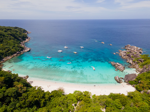 Top and aerial view of beach of one island in Similan Islands of Thailand during daylight with sunny sky and some cloud blue sky and emerald water.