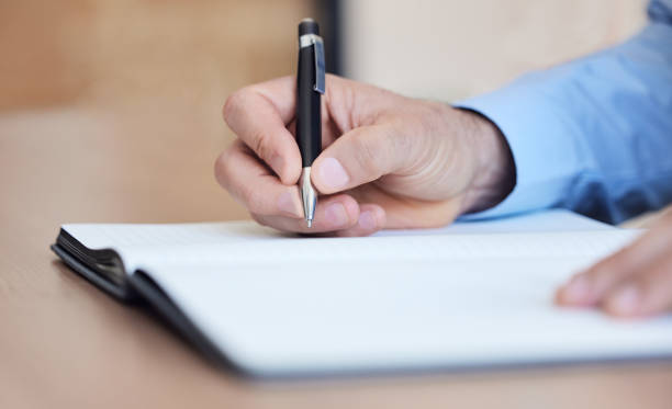 istock Shot of an unrecognizable businessperson writing in a notebook at work 1383016870