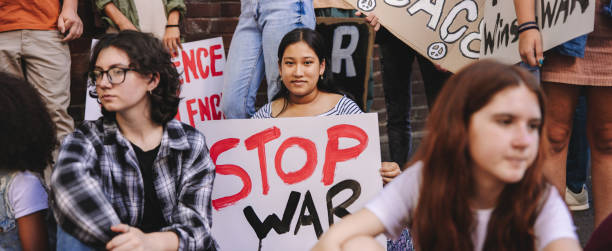 istock Young woman holding an anti-war banner during a protest 1383017041