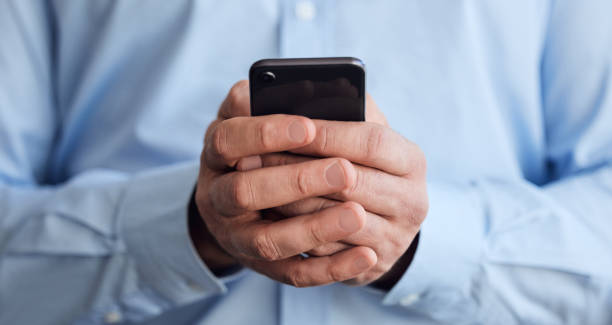 istock Shot of an unrecognizable businessperson using a phone at work 1383019827
