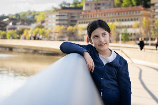 istock Little girl leaning on railing with thoughtful look 1383020735