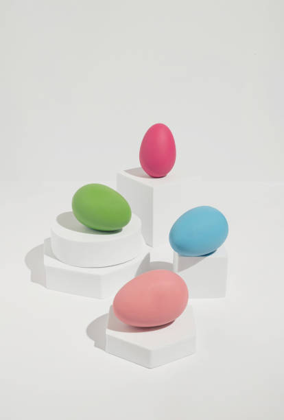 istock Bright Easter concept with four colorful  eggs arranged on white blocks. Modern, minimal spring aesthetic. 1383020789