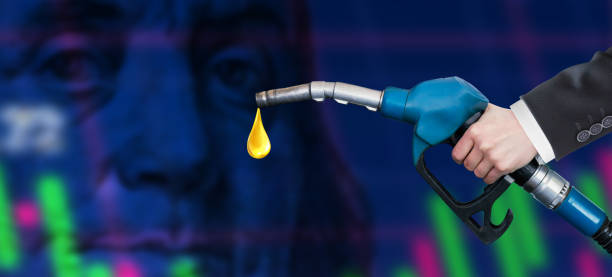 Oil dripping from a gasoline pump on financial data analysis graph showing market trends over American dollar stock photo
