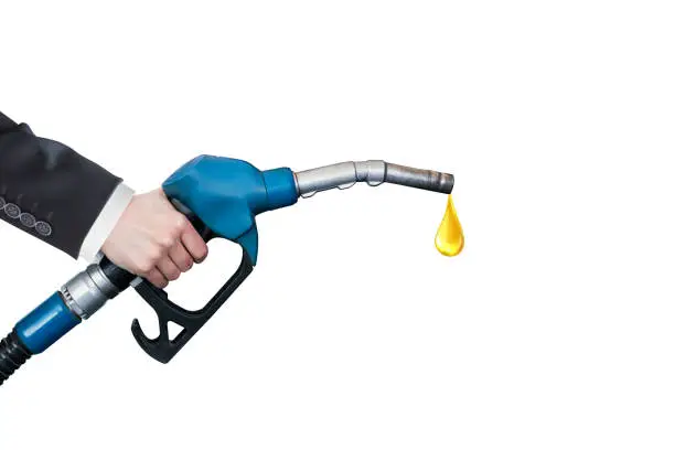 Oil dripping from a gasoline pump on white background