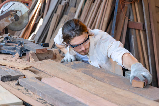 istock Carpenter  is working in workshop. He is sawing a plank. 1383023239