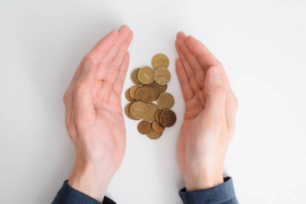 istock Financial problems, crisis, falling value of money, poverty, poor concept. Hands holding, saving stack of golden coins, russian rubles on white table top view, close-up 1383024891