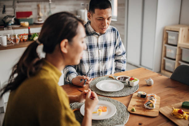 istock Couple eating sushi at home 1383029517