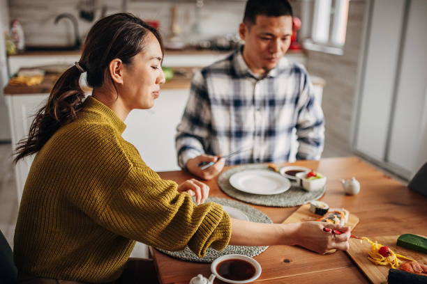 istock Couple eating sushi at home 1383030897