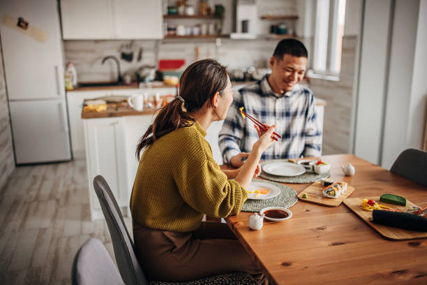 istock Couple eating sushi at home 1383031103
