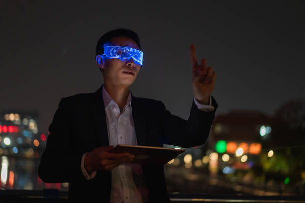 istock Asian male office worker using augmented reality glasses outdoors to experience metaverse game at night 1383031518