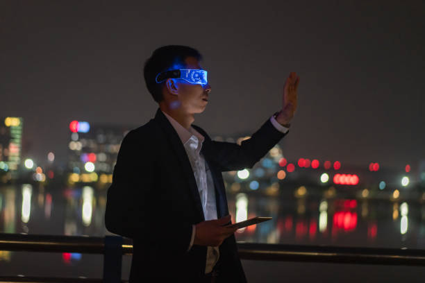 istock Asian male office worker using augmented reality glasses outdoors to experience metaverse game at night 1383032324