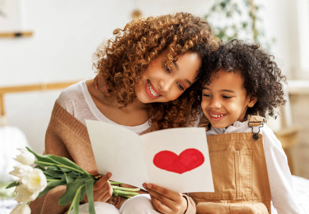 Young ethnic  woman getting congratulations from son on Mothers day