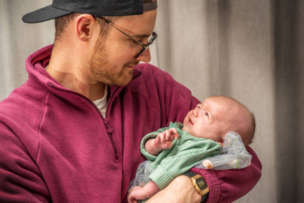 istock Father lovingly holding newborn daughter 1383035017