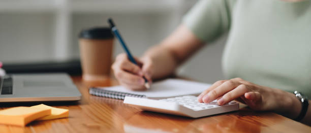 istock close-up shot of accountant using calculator while taking notes on office desk. 1383036728