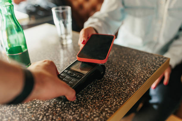 istock Man accepting a digital payment from a customer in a cafe 1383047507