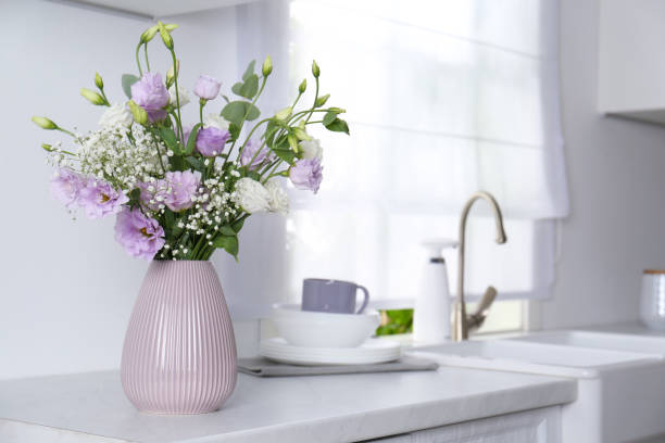 istock Beautiful bouquet with Eustoma flowers on countertop in kitchen. Space for text 1383050551