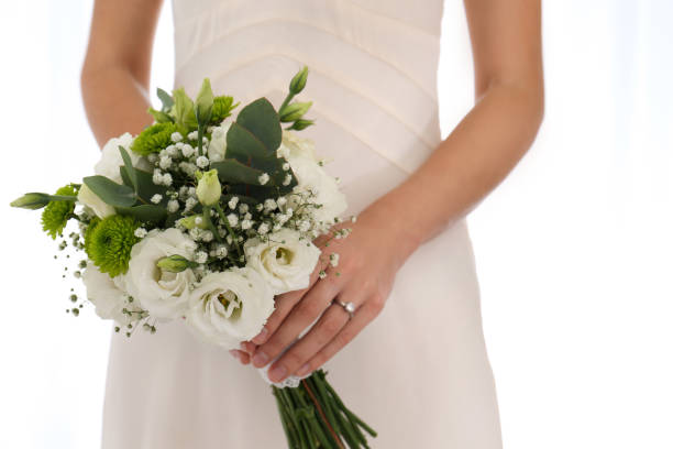 istock Bride holding beautiful bouquet with Eustoma flowers indoors, closeup 1383051021