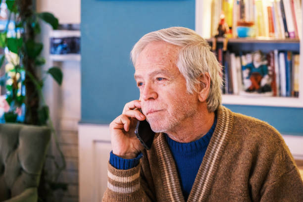 istock Senior man working on digital and talking with phone tablet at cafe 1383055767