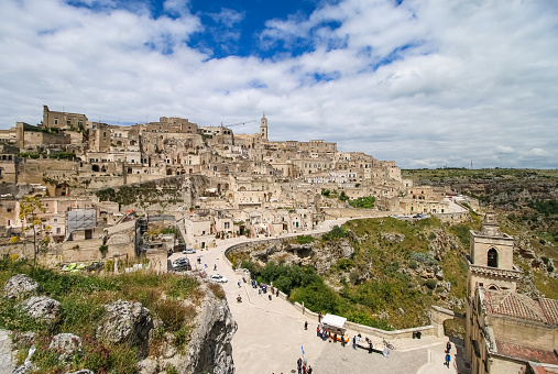 Ancient Unesco heritage old town of Matera (Sassi di Matera), Basilicata, southern Italy. Prehistoric cave dwellings, European Capital of Culture 2019. People are unrecognizable.
