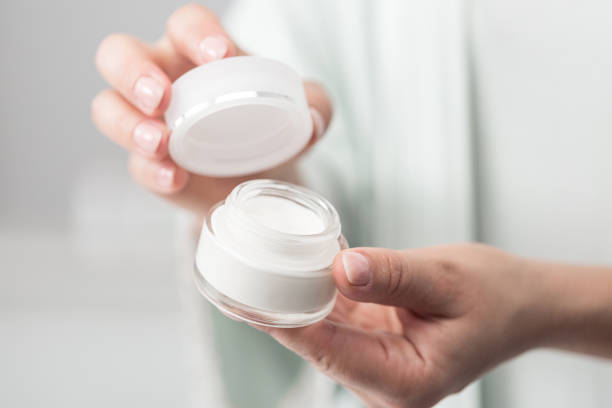 istock Woman holding jar of moisturizer 1383061974