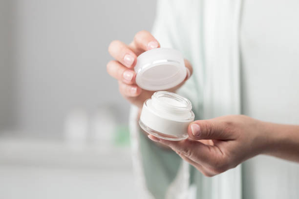istock Woman holding jar of moisturizer 1383062510