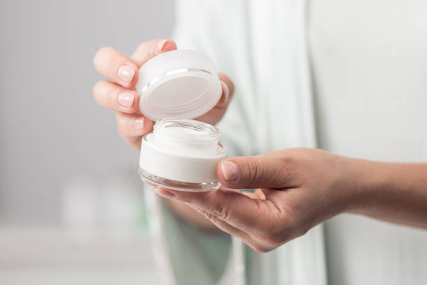 istock Woman holding jar of moisturizer 1383067910