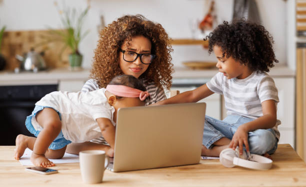 istock Young irritated African-American mother freelancer trying to work while working remotely with kids 1383070053
