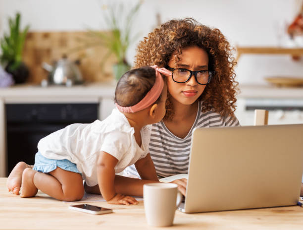 istock Young irritated african-american mother freelancer trying to work while working remotely with little kid 1383070635