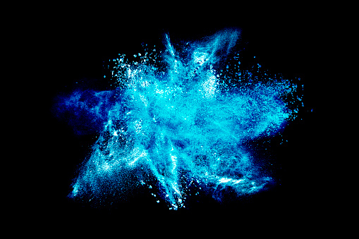Abstract exploding blue powder isolated on black background.