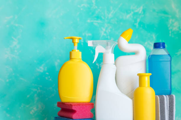 istock Cleaning concept with various plastic bottles and canisters on blue background.cleaning supplies including sponges.various detergents and the necessary attributes for cleaning, washing and ironing. 1383077005