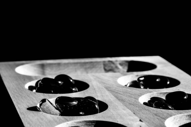 istock Selective focus on glass beads on a wooden mancala board 1383077333