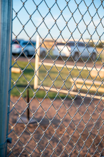 istock Focus on chain link fence with t-ball background 1383077370