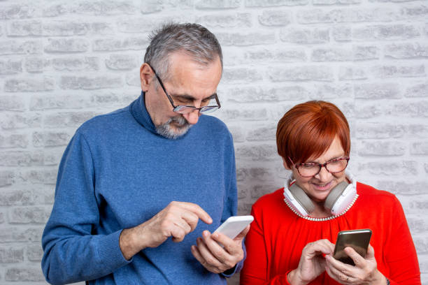 istock Senior couple using smart phone in living room 1383077392