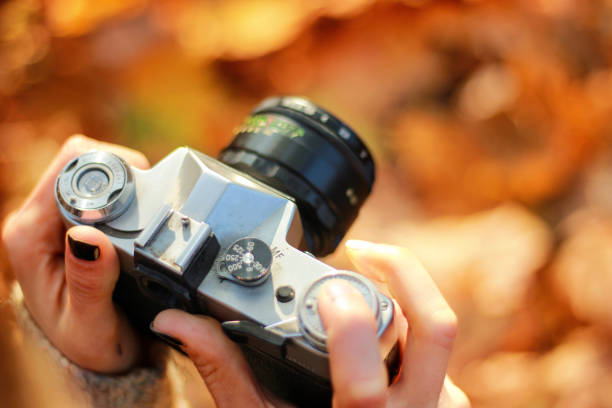 Vintage camera in hand on blurred background. concept: photography courses