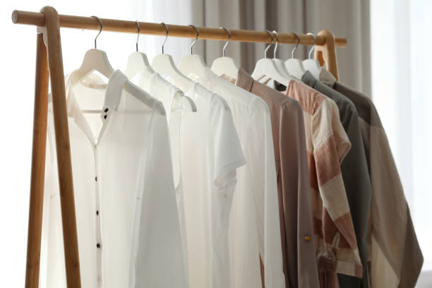 istock Different stylish clothes on rack in room 1383091123