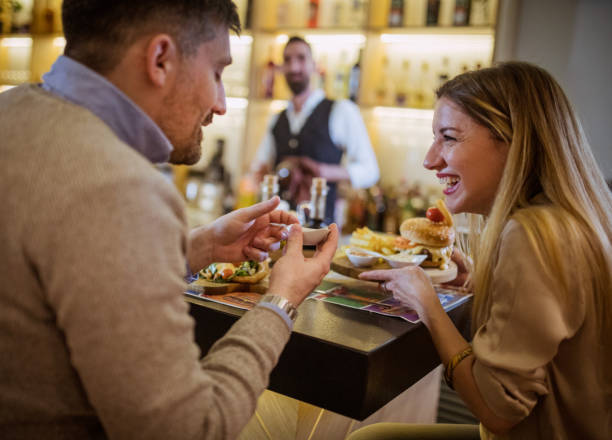 istock Young couple sitting at cafe counter 1383093988