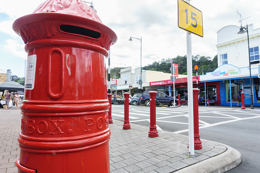 Thames New Zealand - April 11 2015;Low point of view of urban street with bright red traditional post box on corner
