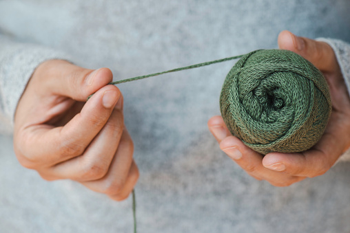 Woman holding woollens yarn balls. Hand made.