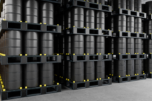 Rows Of Black Metal Oil Barrels In Warehouse