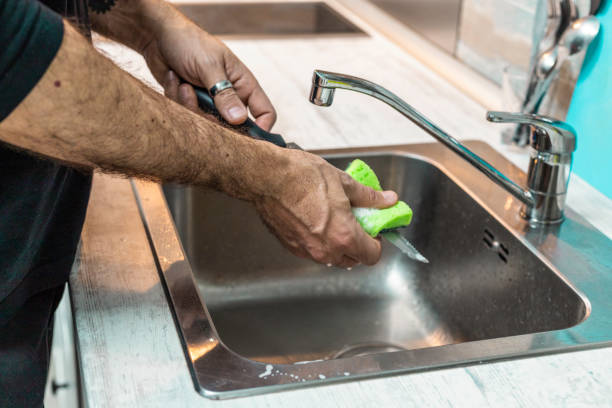 istock Unrecognizable person washing dishes by hand 1383096489